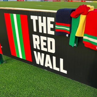 Collection of scarves on the football stand with The Red Wall logo.