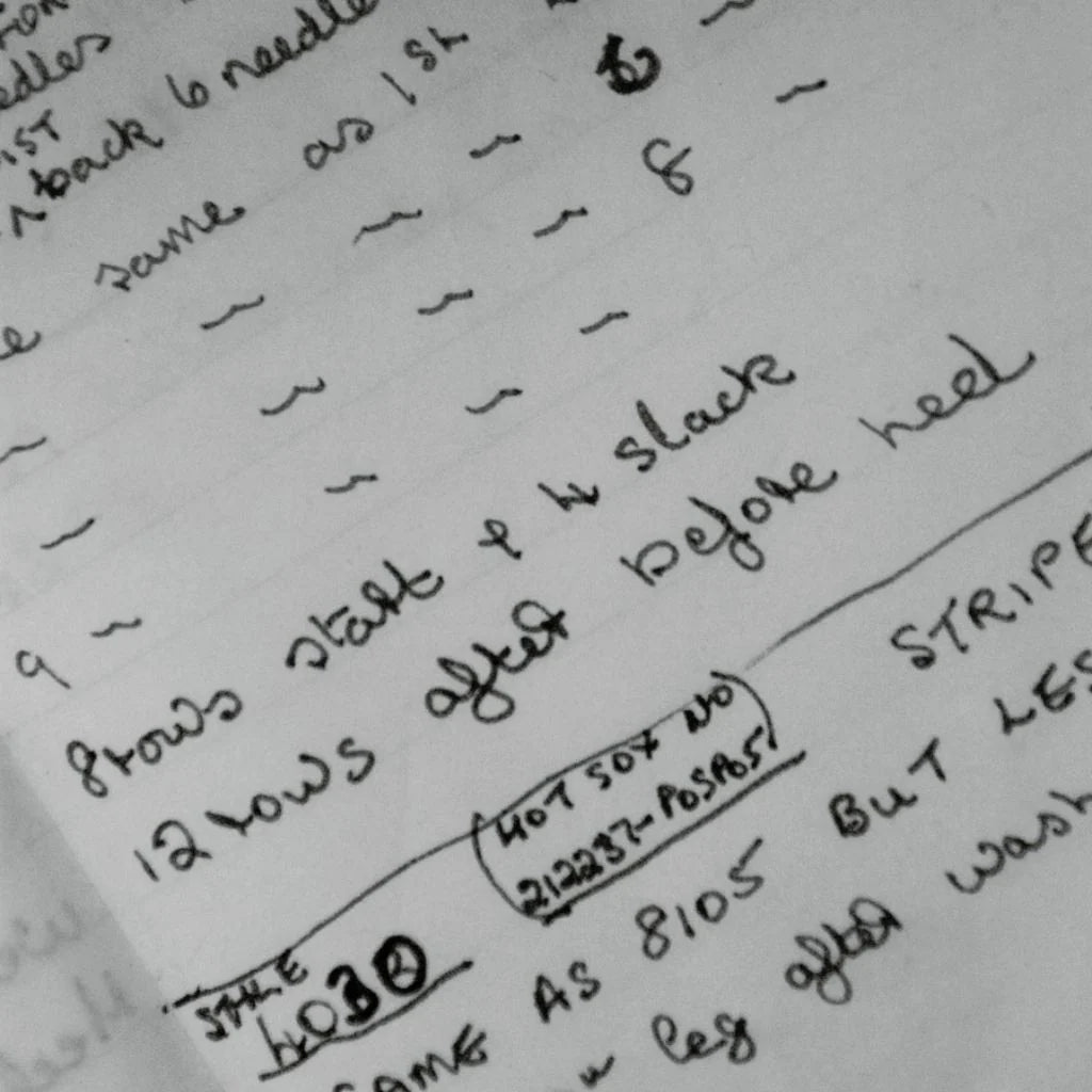 Handwritten knitting instructions on a piece of paper with text and numbers.