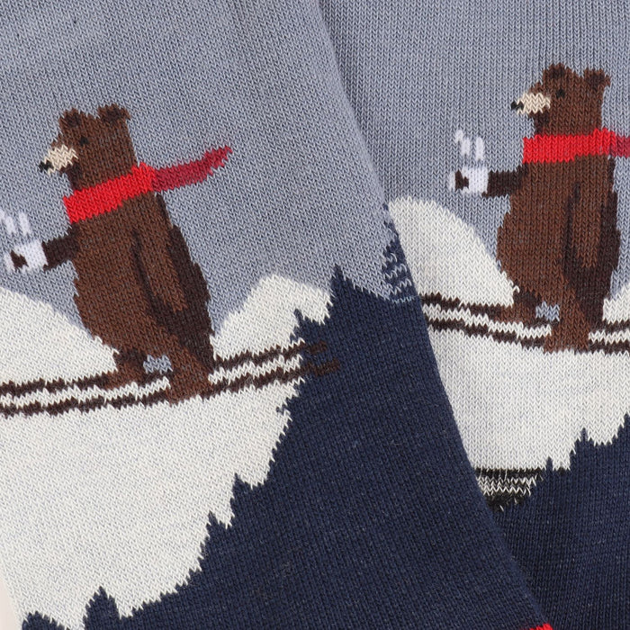 A close up of a  pair of children's socks with a skiing bear design, featuring a blue colour scheme.