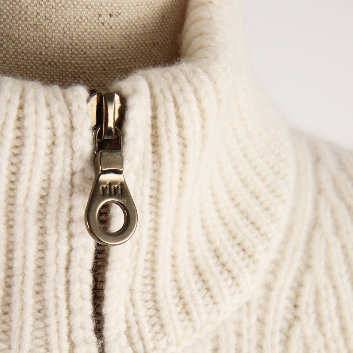 Close-up of a zipper on a beige fabric background