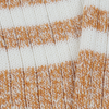 Close-up of a knitted fabric with white stripes on gold marl.