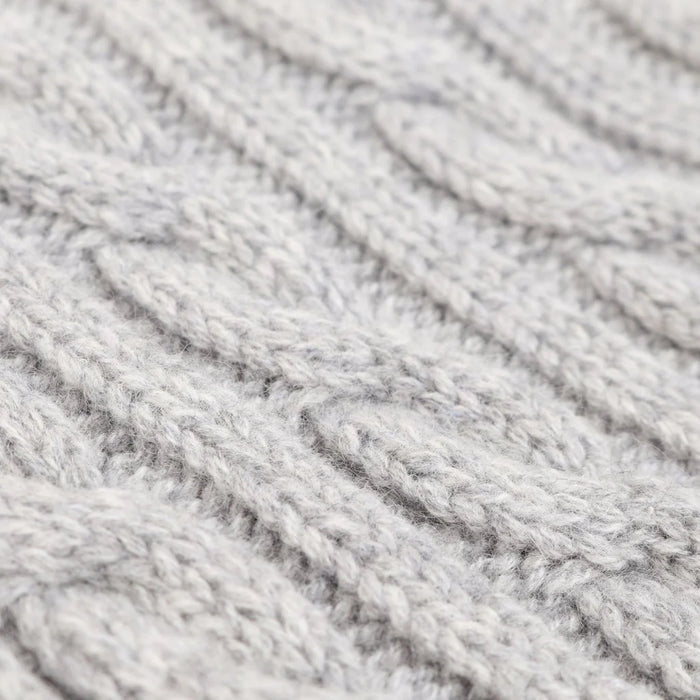 Close-up of grey yarn with a textured cable pattern