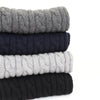 stack of cable scarves on a white background