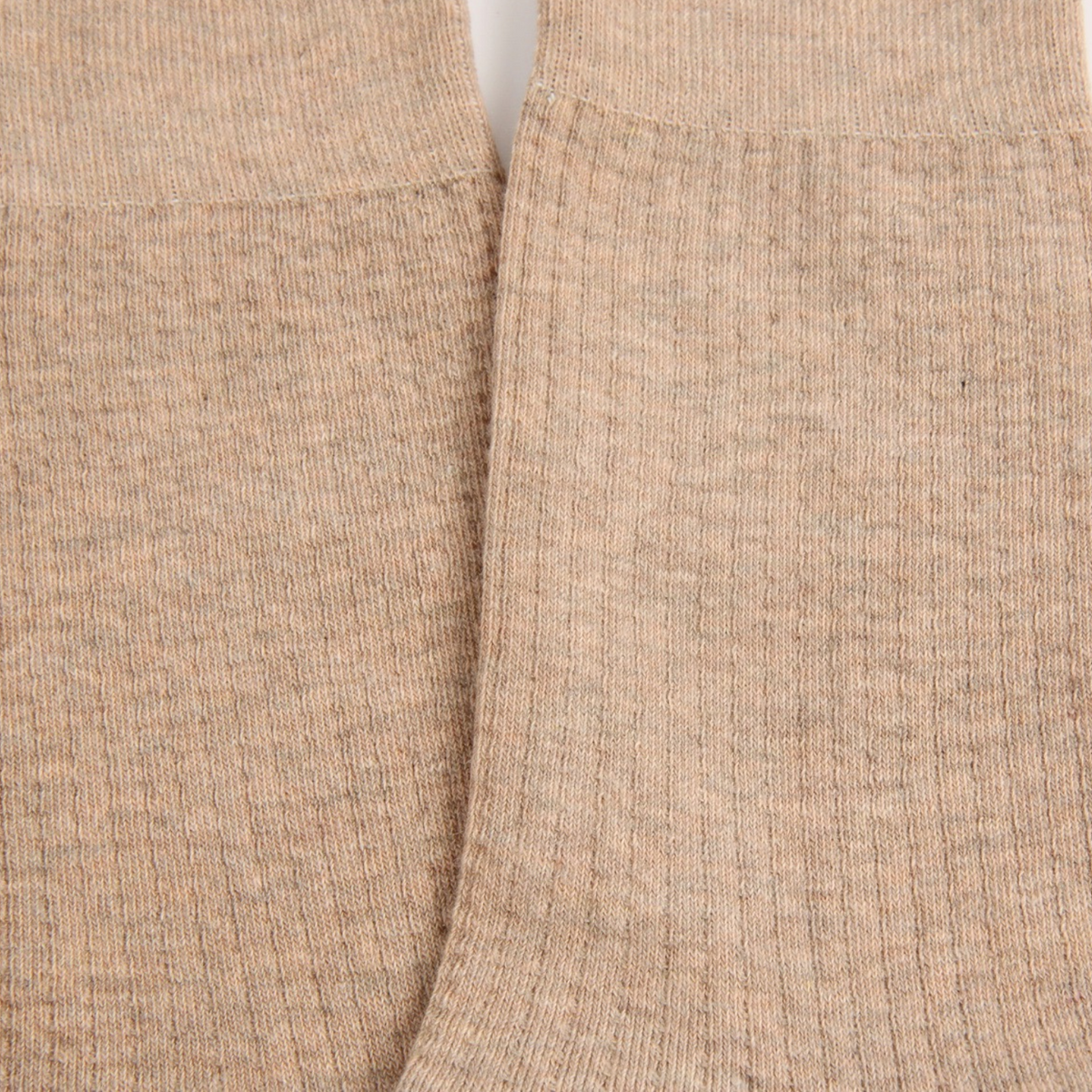 Close-up of a textured knit fabric in a warm heathered beige or oatmeal tone, showing the texture and cuff detail.