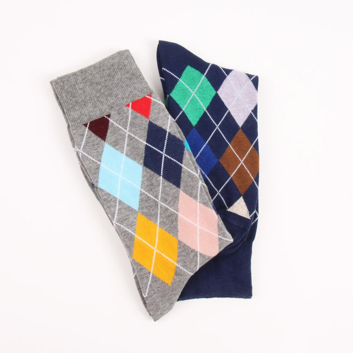 Two pairs of argyle patterned socks, one gray and one blue with multicolor diamonds, photographed on a white background.