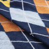 Close-up of a fabric with a blue, orange, and white argyle pattern.