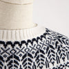 Close-up of a sweater with a navy and white pattern on a neutral background