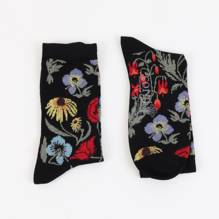 Pair of black socks with colorful floral patterns on a white background