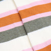 Close-up of striped fabric with pink, orange, gray, and white colors.