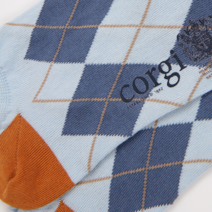 Close-up of a fabric with a checkered pattern and 'corgi' branding.