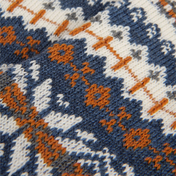 Close-up of a knitted fabric with a pattern of blue, orange, and white.