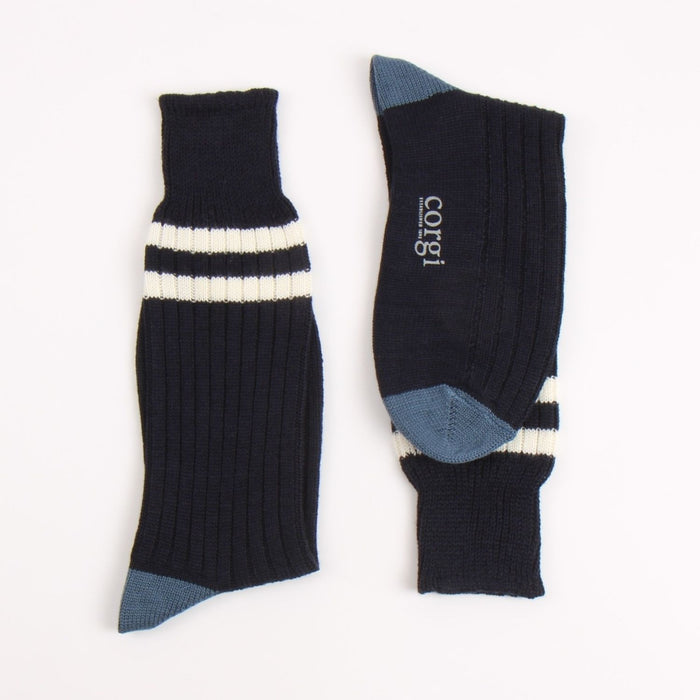 Navy socks with two white stripes and blue accents heel and toe, photographed on a white background