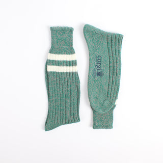 Pair of green socks with a white stripe photographed on a white background