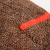 Close-up of brown fabric with a orange stripe on a white background