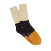 A pair of men's color block donegal wool socks with a black, beige, and yellow design, mid-calf length, with a ribbed cuff.