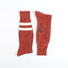 Pair of red knitted socks with a white stripe on a white background
