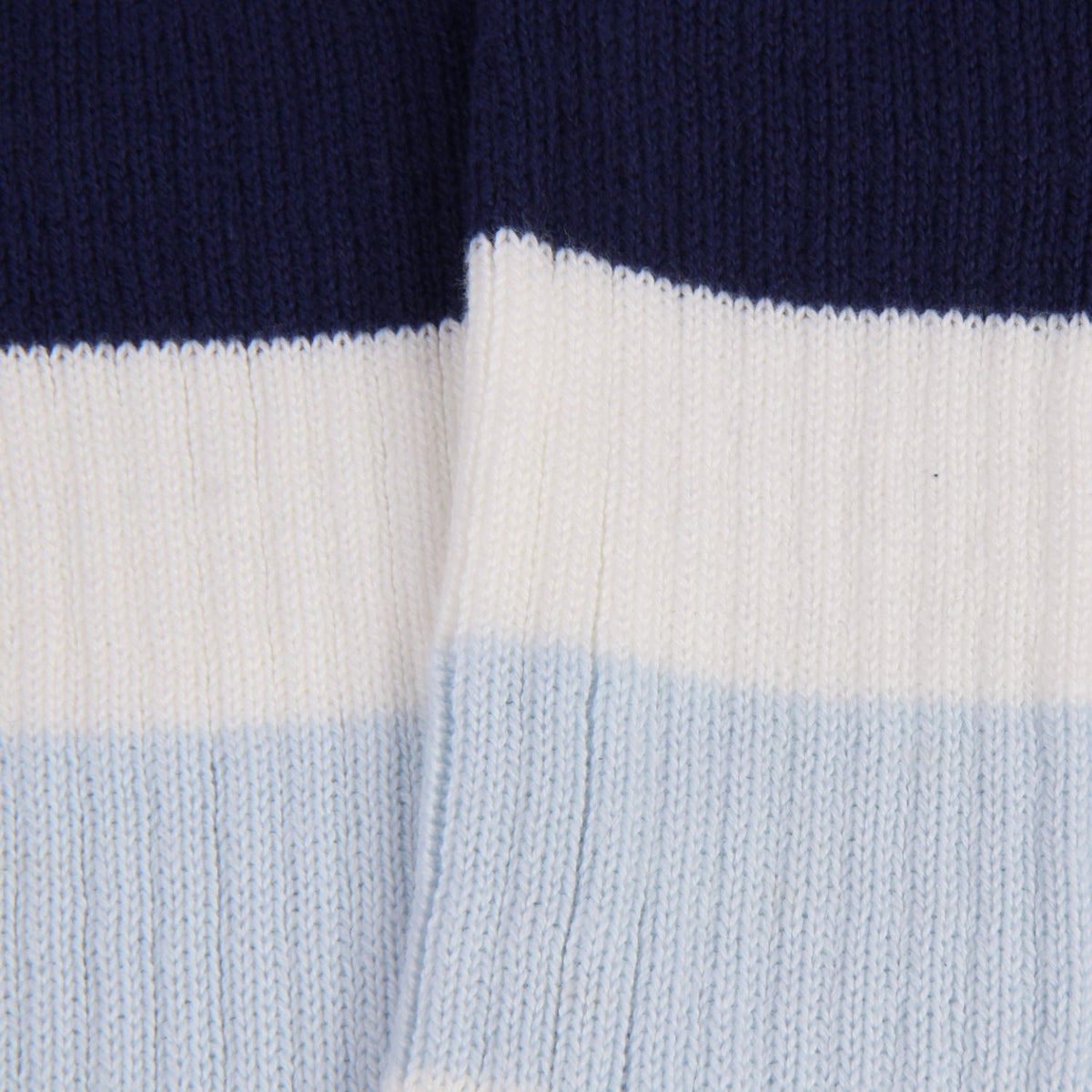 Close-up of a sock with navy, white, and light blue horizontal stripes.