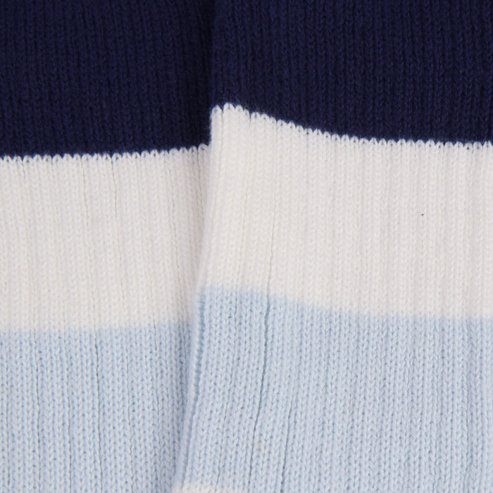 Close-up of a sock with navy, white, and light blue horizontal stripes.