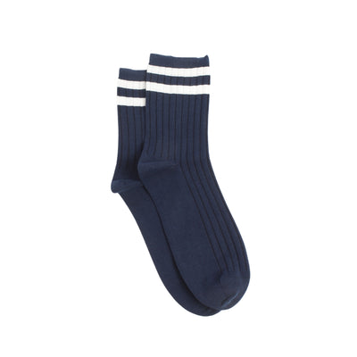 Navy blue socks with two finer white stripes on the top section of the sock photographed  on a white background