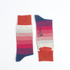 Two striped socks with red, pink, and blue colours photographed on a white background