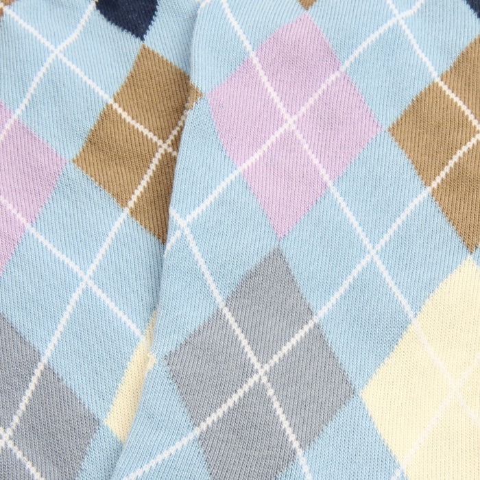 Close-up of a patterned fabric with diamond shapes in various colors on a light blue background.