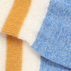 Close-up of fabric with orange, white, and blue stripes.