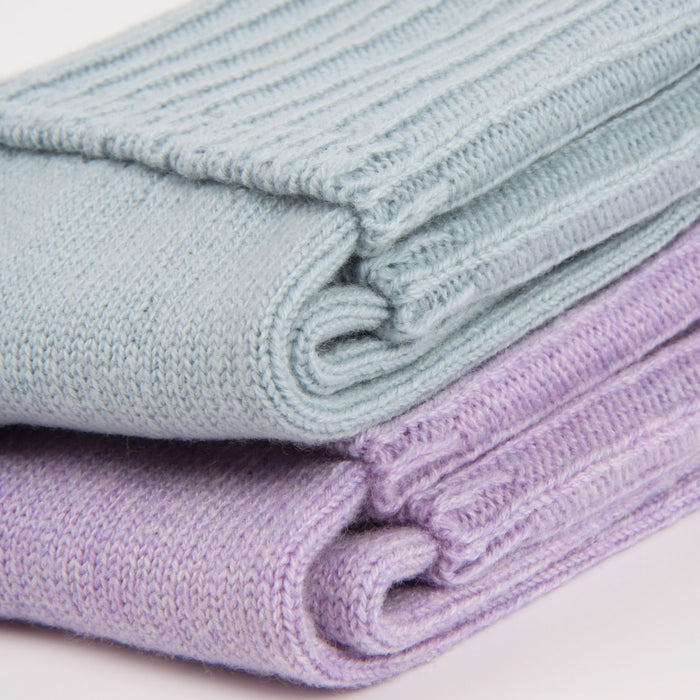 Stack of folded light blue and purple socks on a white background

