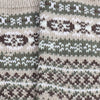 Close-up of a knitted fabric with a pattern featuring brown, green, and white colors.