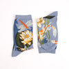 Pair of socks with floral and dragonfly design on a light blue background