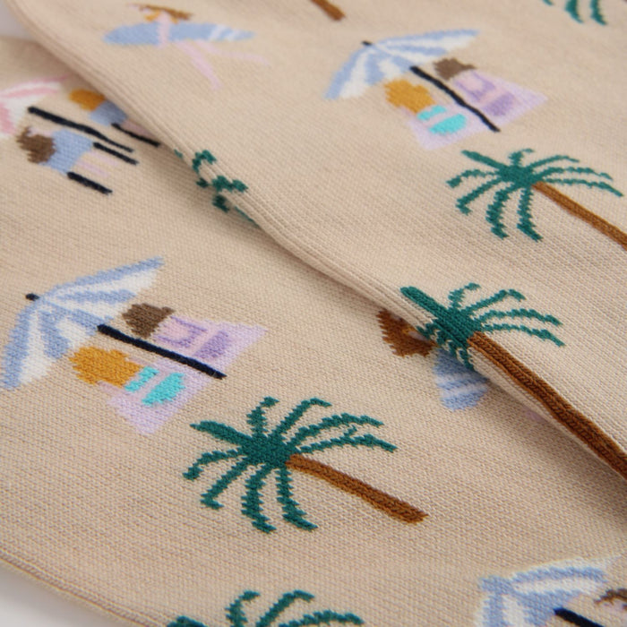 Close-up of fabric with beach-themed mini icons including palm trees and umbrellas.