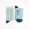 Pair of light blue socks with a mini pelican all over pattern photographed on a white background