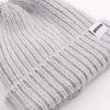 Grey knit beanie with a brand label on a white background