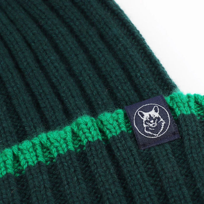 Green knitted beanie with a logo tag on a white background