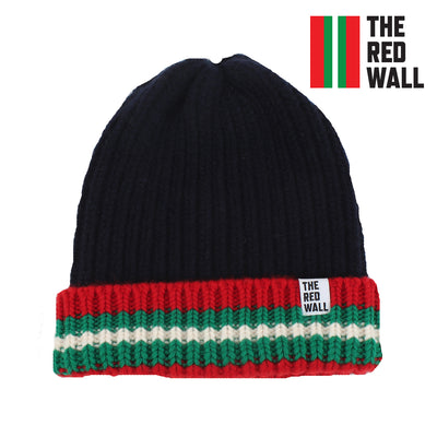 A navy ribbed beanie hat with red and green striped detailing at the brim, featuring the Red Wall logo.