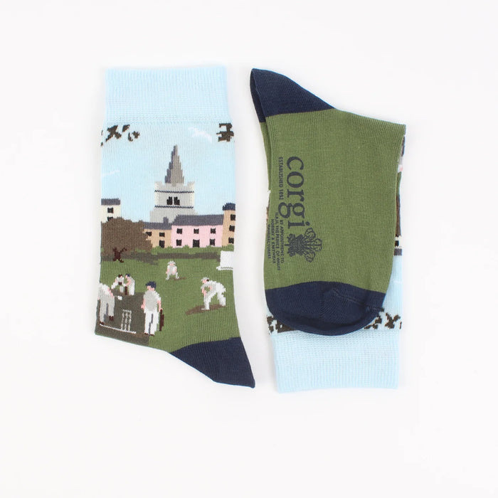 A pair of patterned cotton socks featuring a cricket scene with players on a green field, designed for children.