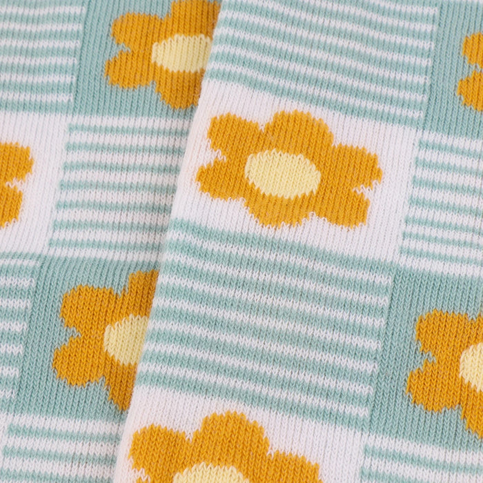 close up of the sock knitted fabric with a floral pattern in pink and aqua green colours.