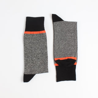 Pair of gray socks with black and orange accents on a white background