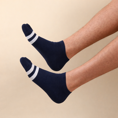 Navy socks with white stripes worn by a person on a beige background
