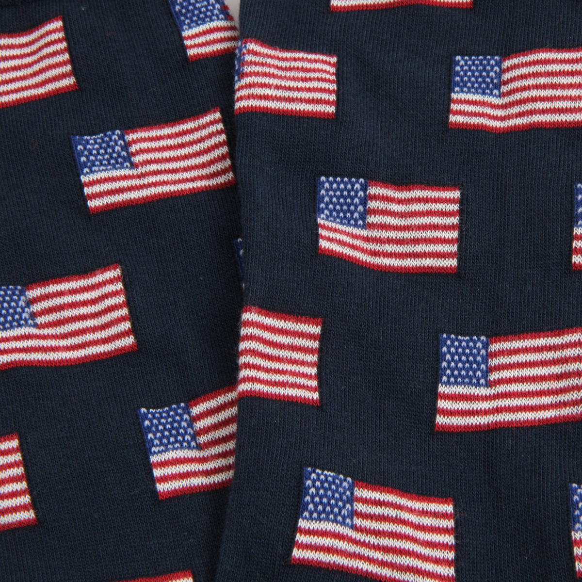 Close-up of dark navy knit fabric with an allover pattern of small American flags in red, white, and blue.
