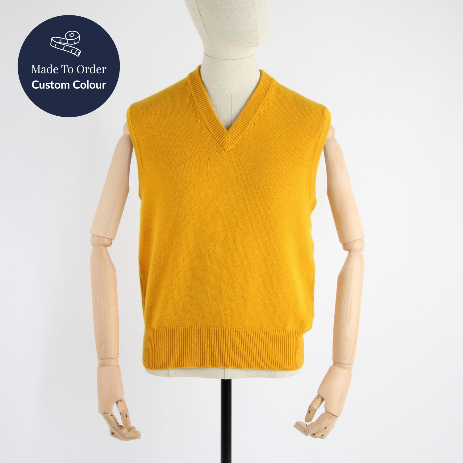 Yellow sweater vest on a mannequin with 'Made To Order Custom Colour' label.