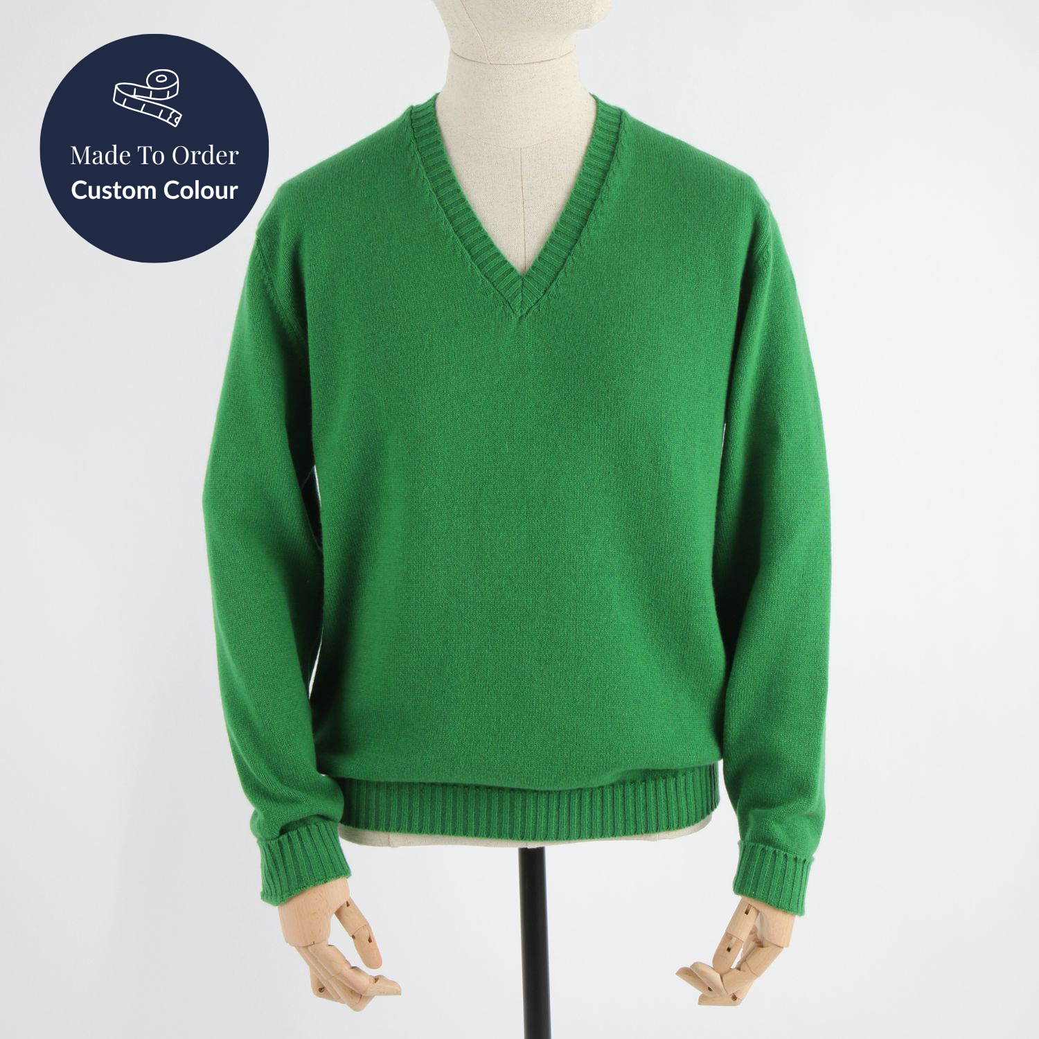 Green sweater on a mannequin with 'Made to Order Custom Colour' label.
