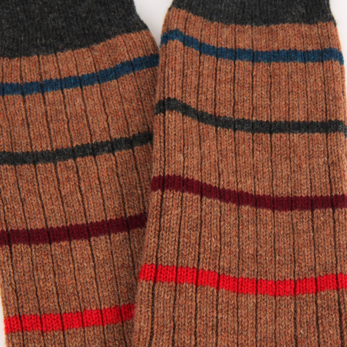 Close-up of brown striped socks with red, blue, and black stripes.
