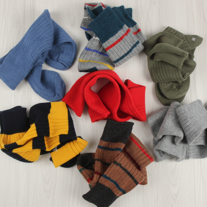 Assorted colorful socks on a light wooden surface