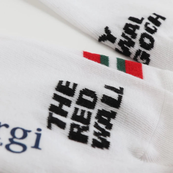 White socks with black text and red, green, and white striped logo on a white background