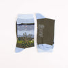 Pair of socks with a scenic design and brand logo on a white background