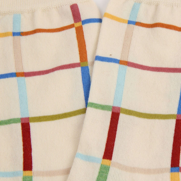 Close-up of plaid patterned fabric with multicolor lines on a beige background