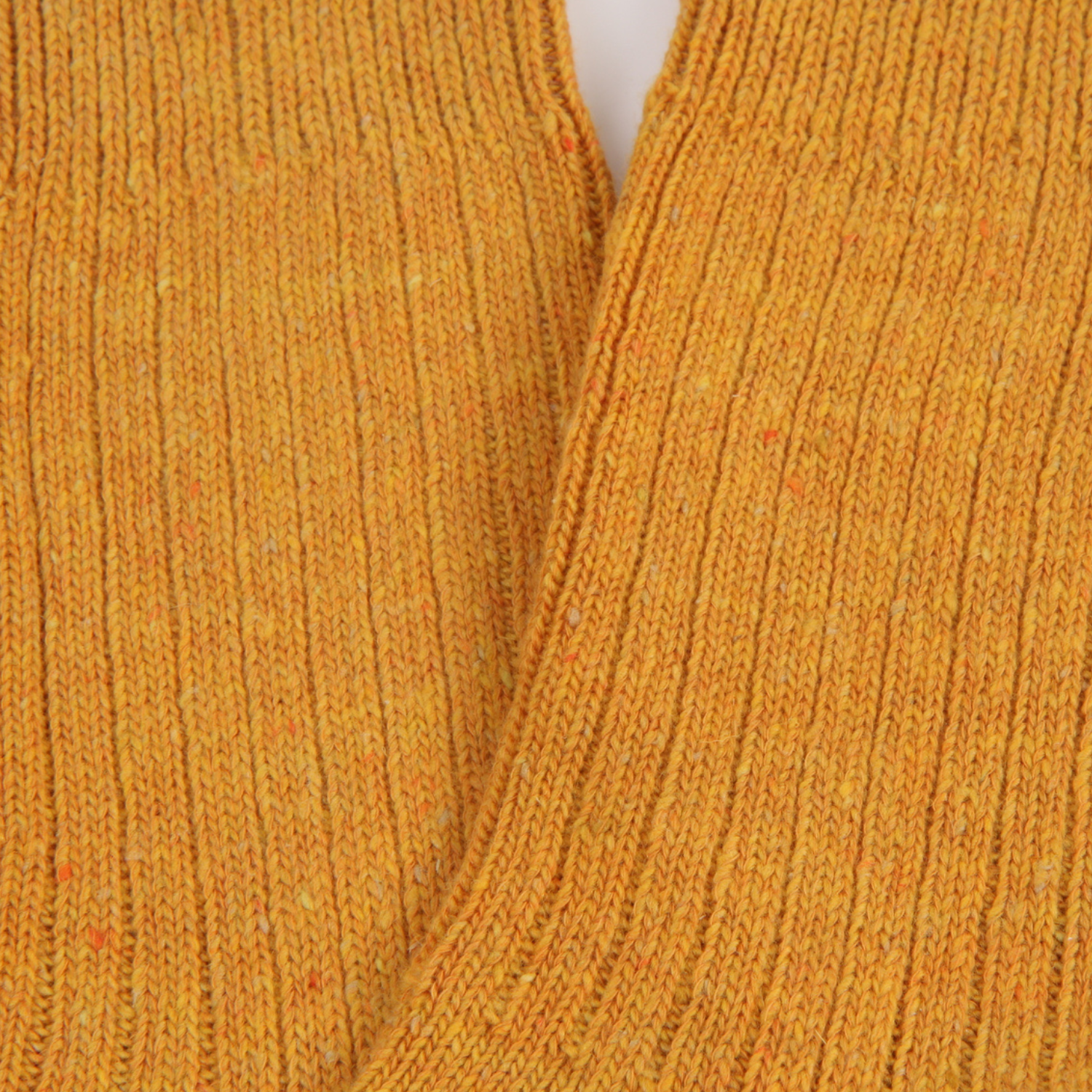 Close-up of a mustard yellow knitted fabric texture