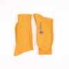 Pair of mustard yellow socks with 'corgi' branding on a white background