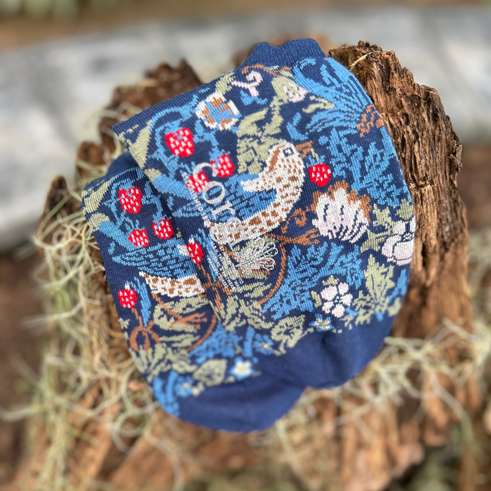 close up of floral trainer socks on bark 