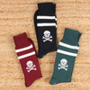 Three socks with skull and crossbones design on a textured surface
